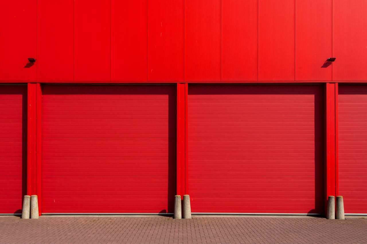 Vivid red garage doors in a sleek industrial building, exuding modern architecture.